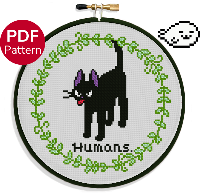 cross stitch pattern of a cat sticking his tongue out with an angry face with the text 'humans.' under it