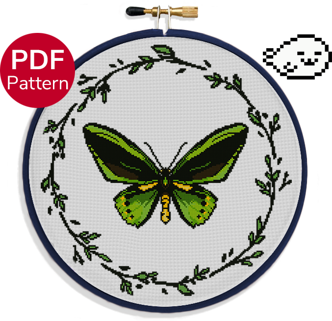 cross stitch pattern of a green birdwing butterfly with a wreath of leaves around it